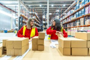 two women in a warehouse packaging for distribution