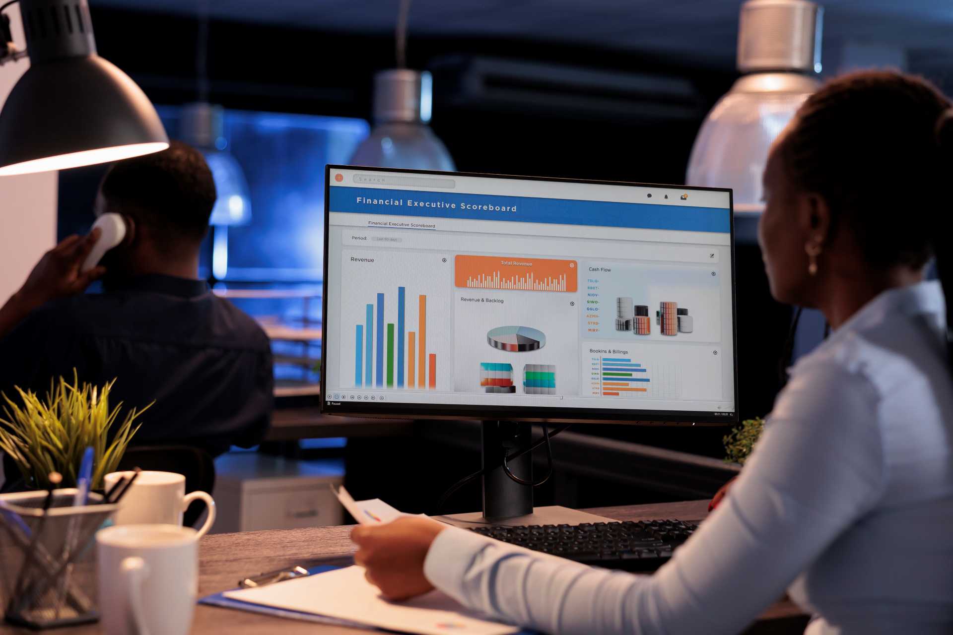 Business Central implementation partner, a female employee seen working with statistics charts on a desktop monitor
