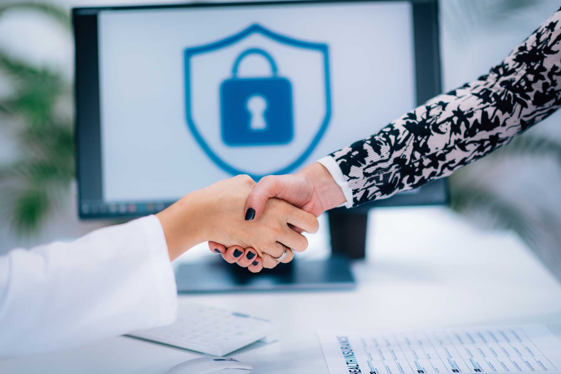 business central GDPR, two people shaking hands in front of a screen with a secure padlock image.