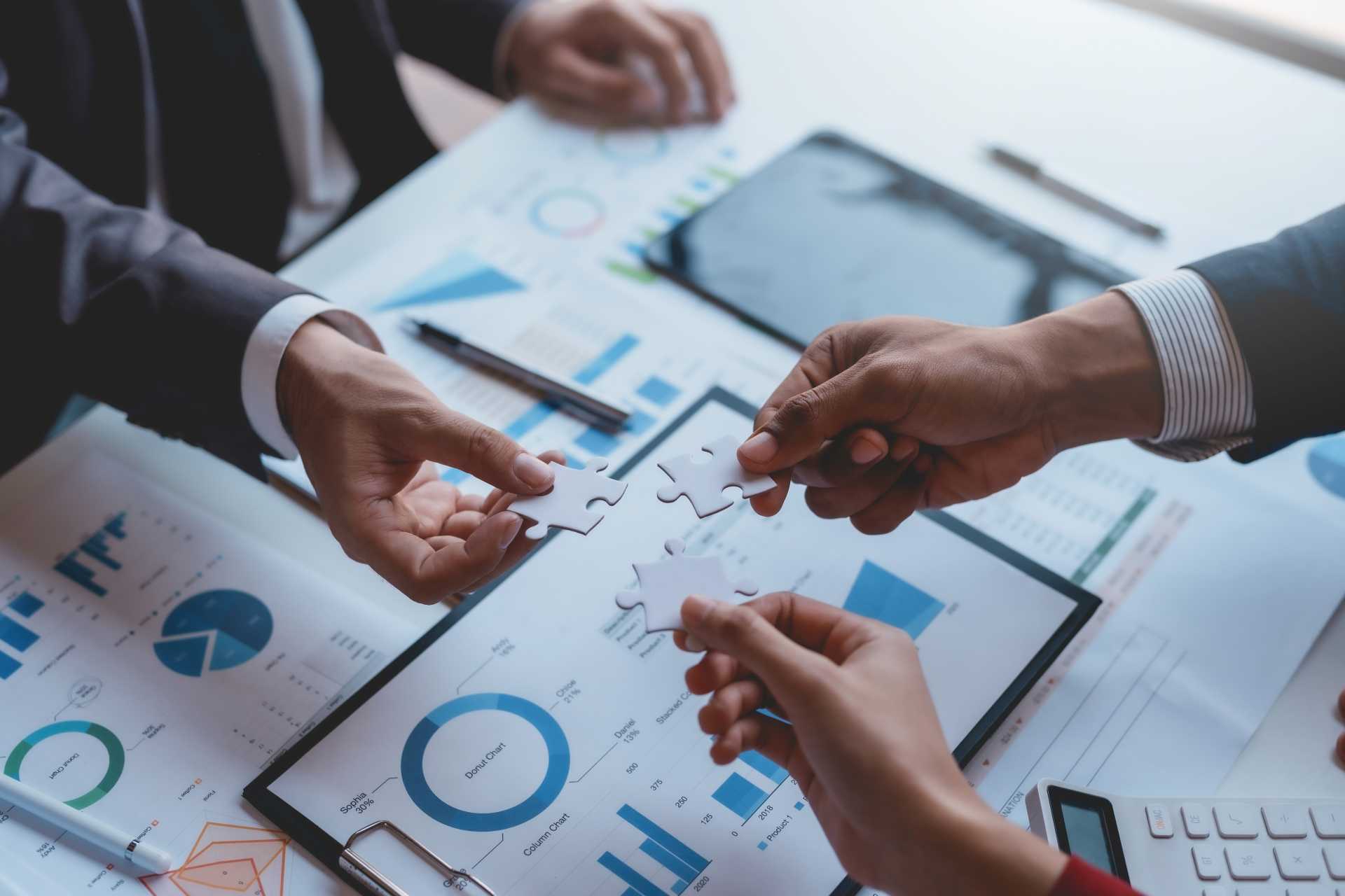 erp implementation challenges, A team of three each holding a piece of a jigsaw.