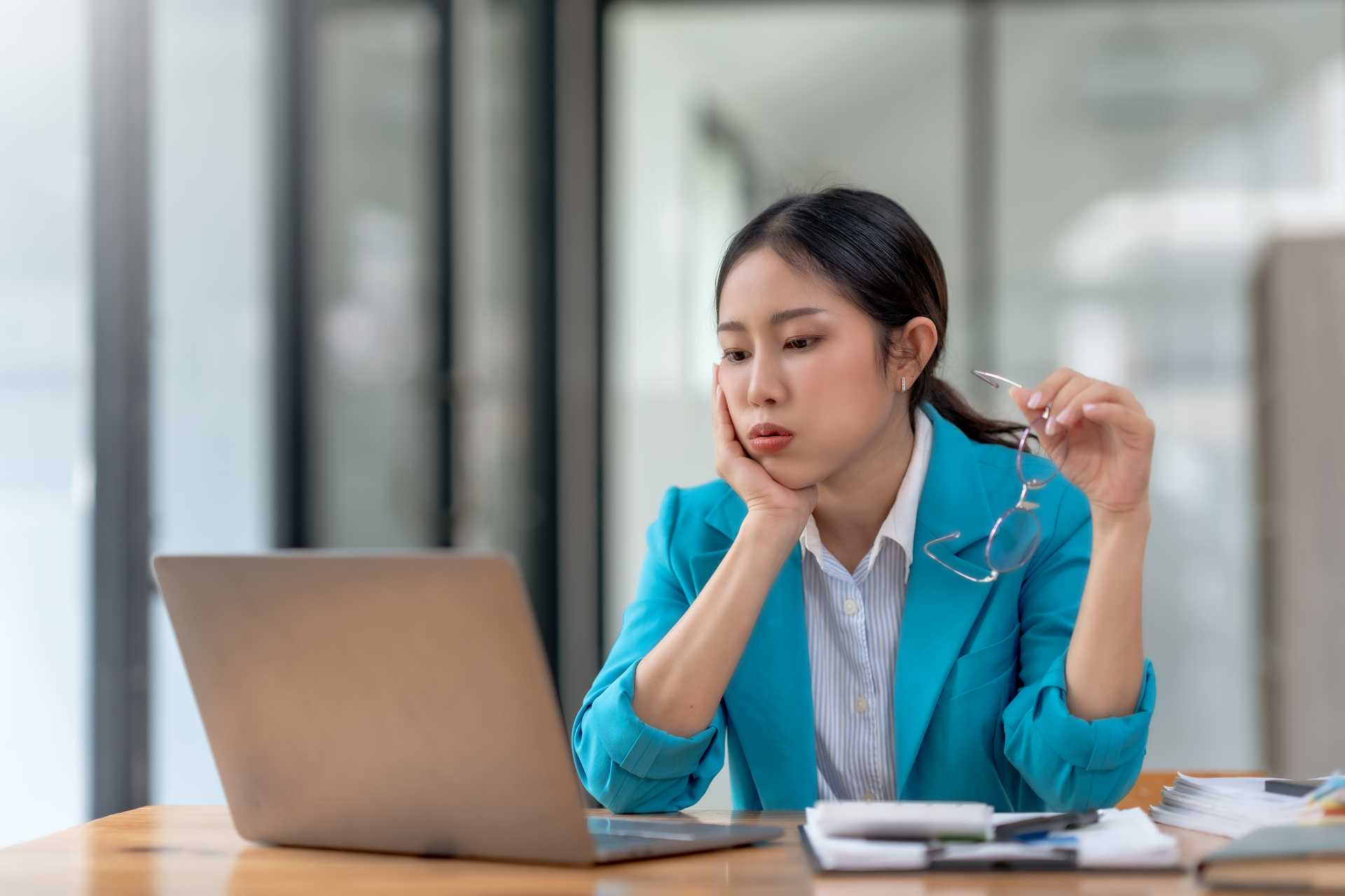 erp migration failure, A stressed businesswoman looking at her laptop.