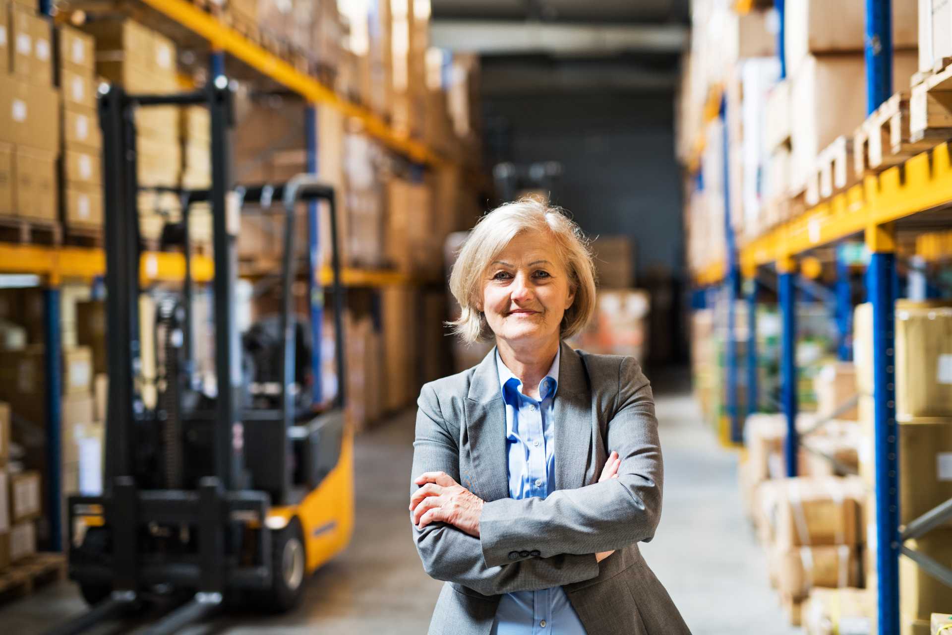 cloud ERP distribution, A senior female manager standing in a distribution warehouse.