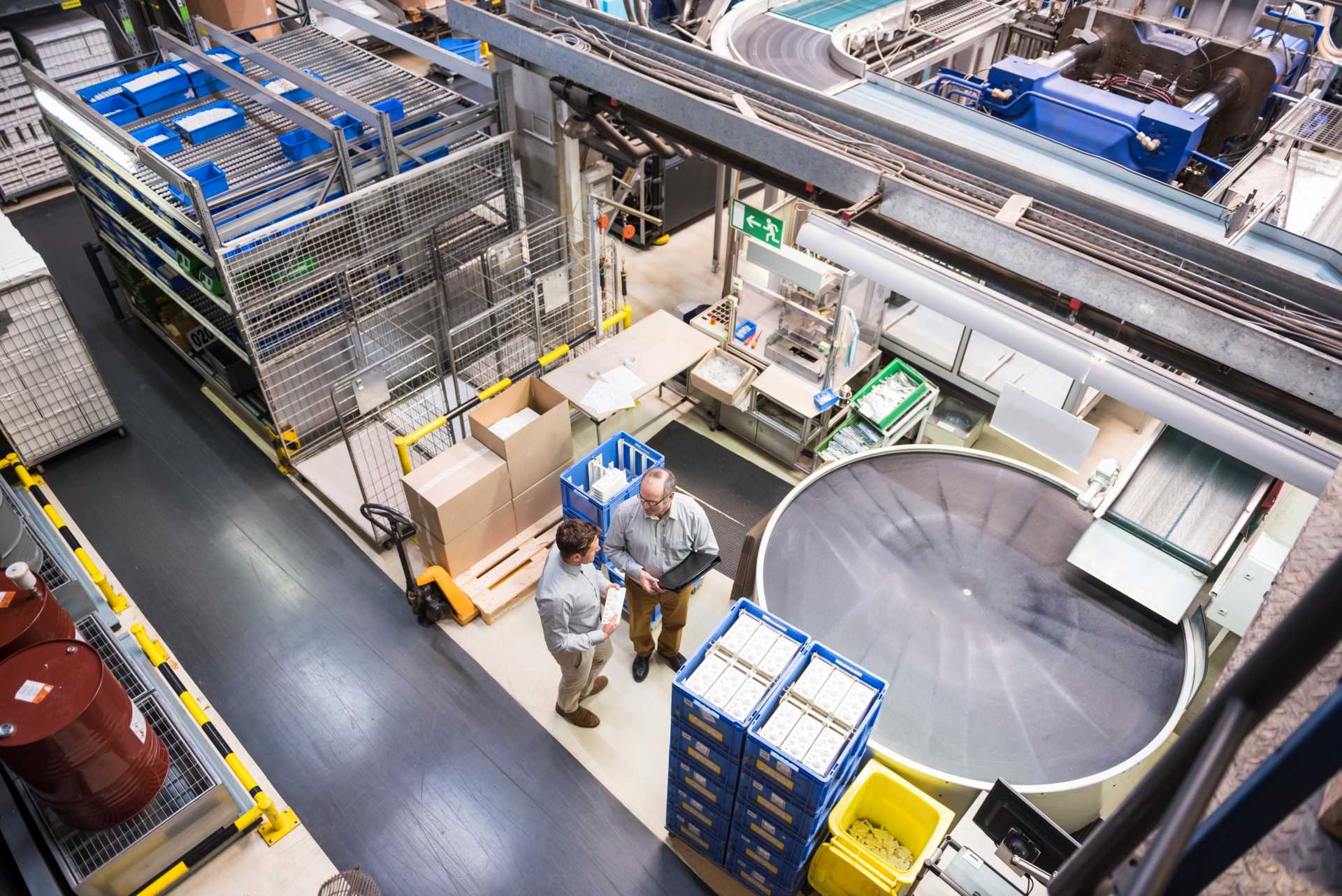 how to choose erp partner for manufacturing business, A view of two men talking on a factory floor.