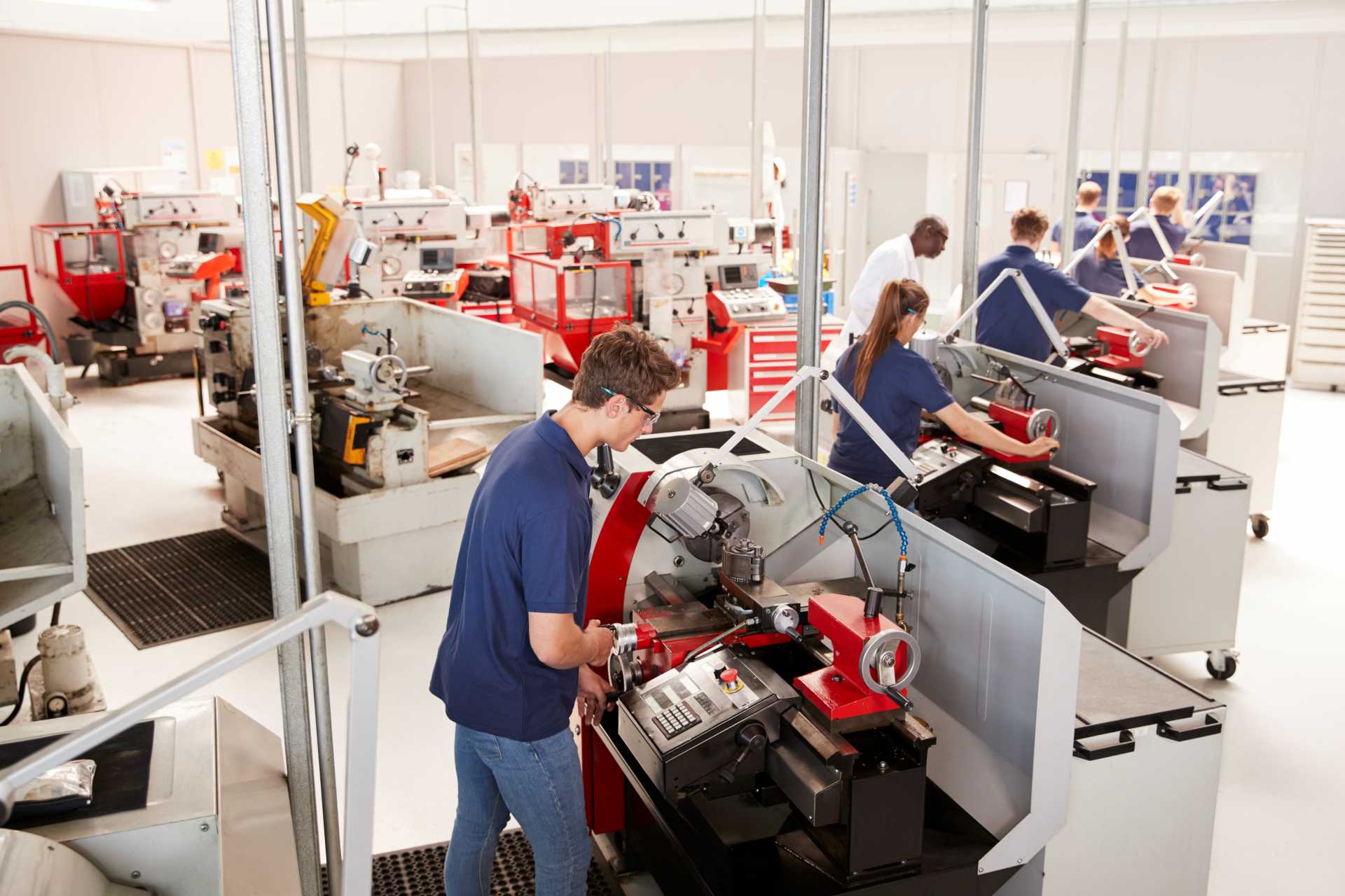 supply chain disruption mitigation strategy, A shop floor with people working with machinery.